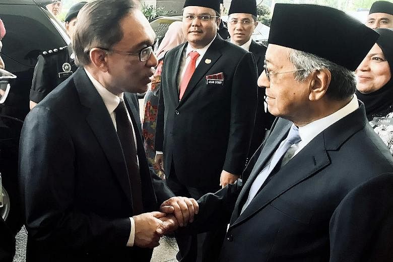Freed Malaysian politician Anwar Ibrahim (left) being greeted by Prime Minister Mahathir Mohamad at Istana Negara in Kuala Lumpur yesterday. Datuk Seri Anwar had emerged earlier from a rehabilitation hospital in Cheras, where he was serving his sente