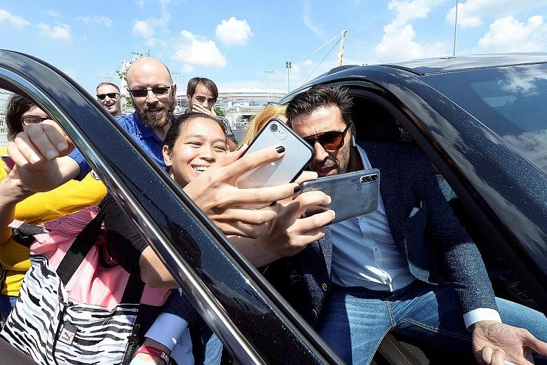 Juventus goalkeeper Gianluigi Buffon poses for pictures with fans in front of the Allianz Stadium after a news conference in Turin yesterday.