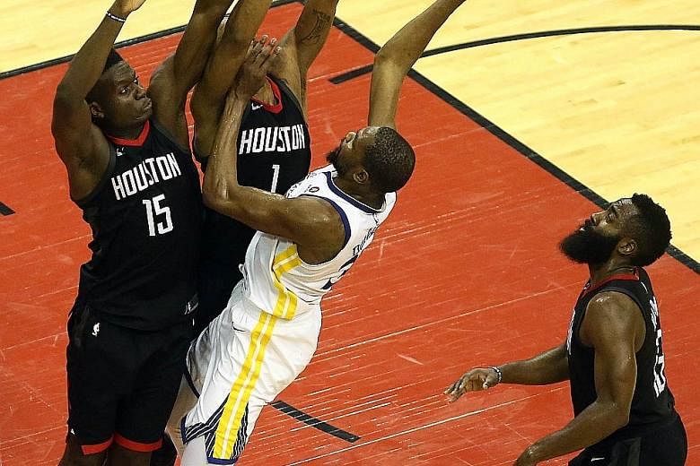 Golden State Warriors forward Kevin Durant (right), who had 38 points for the losing side, finds himself closely guarded by Houston Rockets centre Clint Capela (15) and forward Trevor Ariza during Game 2 of the Western Conference Finals in Houston.