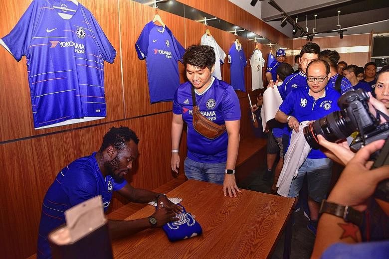 Jonathan Tan, a financial planner, is thrilled to have his Chelsea scarf signed by Michael Essien, who was in town for the club's fan and partner activities on Tuesday.