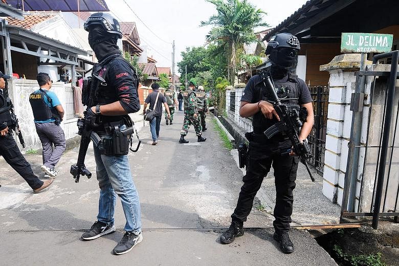 Officers from the anti-terrorism squad Densus 88 carrying out a raid in Tangerang in Java on Wednesday, following a spate of terror attacks in Indonesia.
