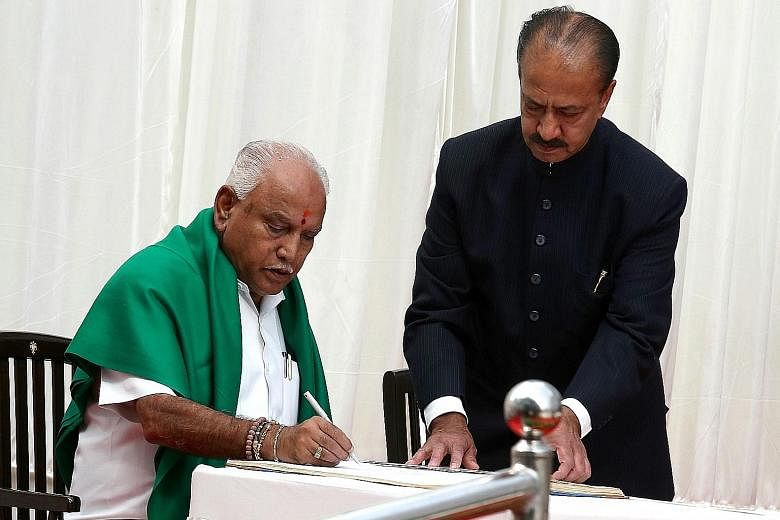 Mr B. S. Yeddyurappa signs the documents after he was sworn in as Chief Minister of Karnataka in Bangalore yesterday. The Congress party had tried to stop him from taking the oath.