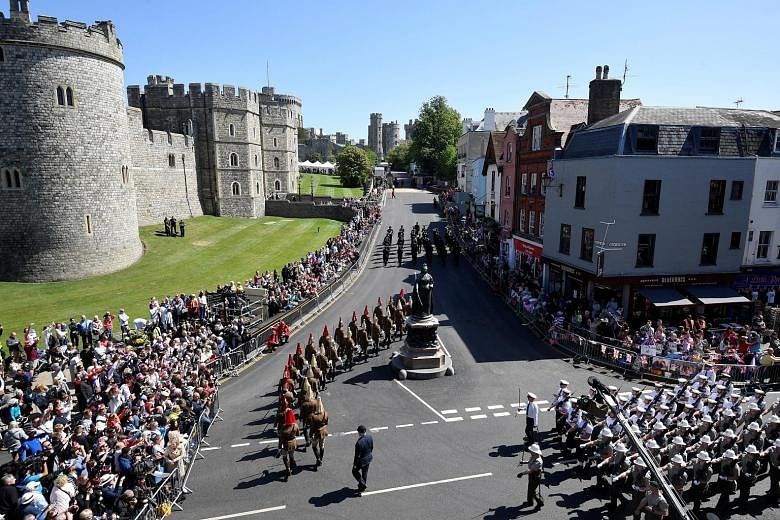 Police officers and members of the public watch as military personnel rehearse their part in the procession through the streets of Windsor for Prince Harry and Meghan Markle's wedding.
