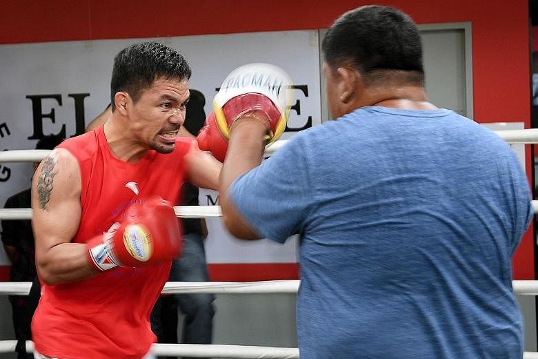 Manny Pacquiao sparring with his childhood friend and assistant trainer Restituto "Buboy" Fernandez during a training session in Manila on Thursday. Pacquiao is due to challenge Argentinian Lucas Matthysse for the WBA welterweight title on July 14.