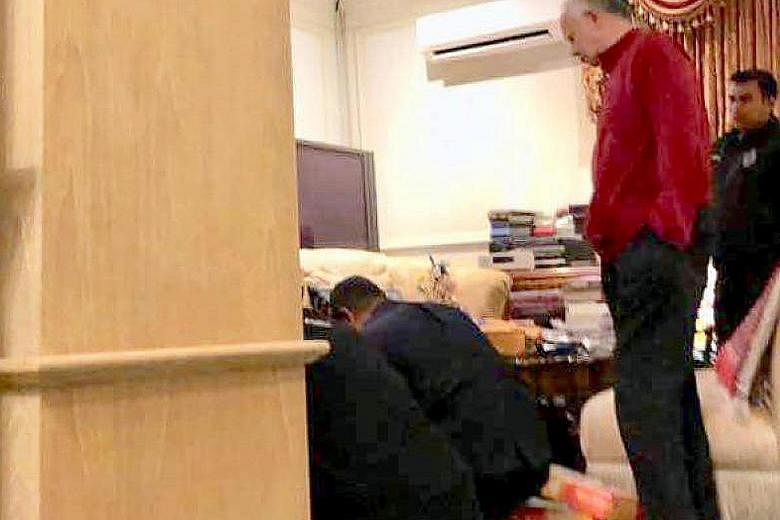 A picture circulating on social media showing Mr Najib Razak watching police officers at work during a raid on his home in Kuala Lumpur. The posh condominium where three apartments, owned by former premier Najib Razak's family, were raided by police 