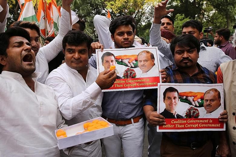Congress party supporters in New Delhi celebrating after the resignation of Bharatiya Janata Party's chief minister on Saturday. Mr B.S. Yeddyurappa had stepped down just before he was to face a vote of confidence in the Karnataka state assembly.
