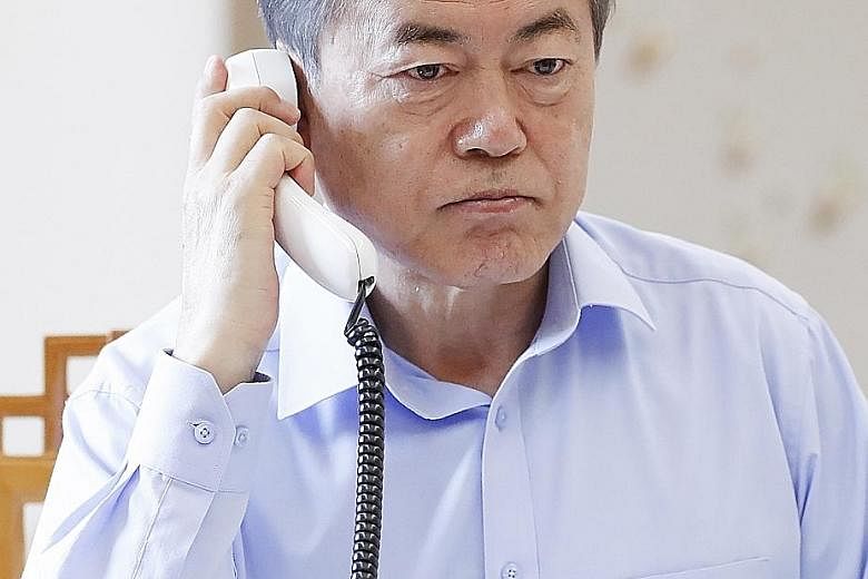 President Moon Jae In talking with President Donald Trump on the telephone at the Blue House presidential office in Seoul yesterday, ahead of their meeting tomorrow in Washington.
