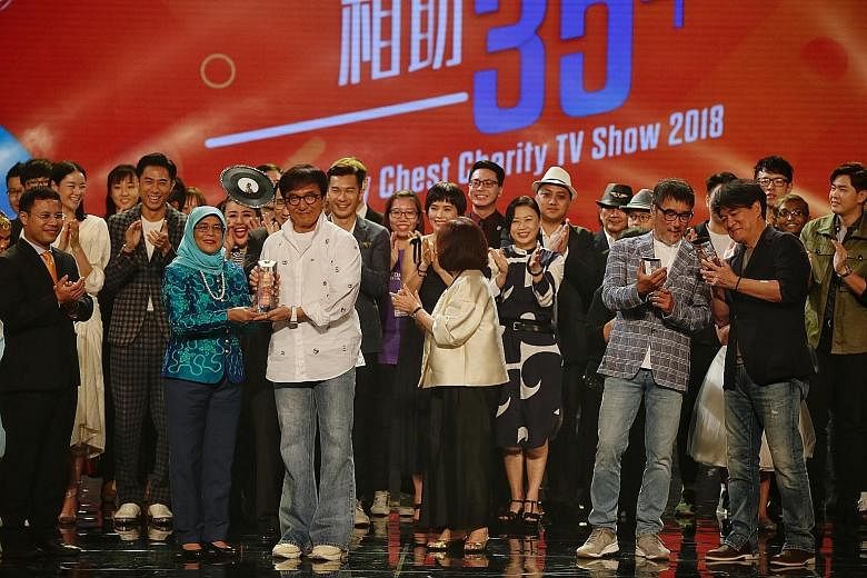 President Halimah Yacob presenting a Community Chest Enabler Award to actor Jackie Chan at the Community Chest Charity TV Show last night. Taiwan-based singer Wakin Chau (foreground, far right) and Taiwanese music producer and singer-songwriter Jonat
