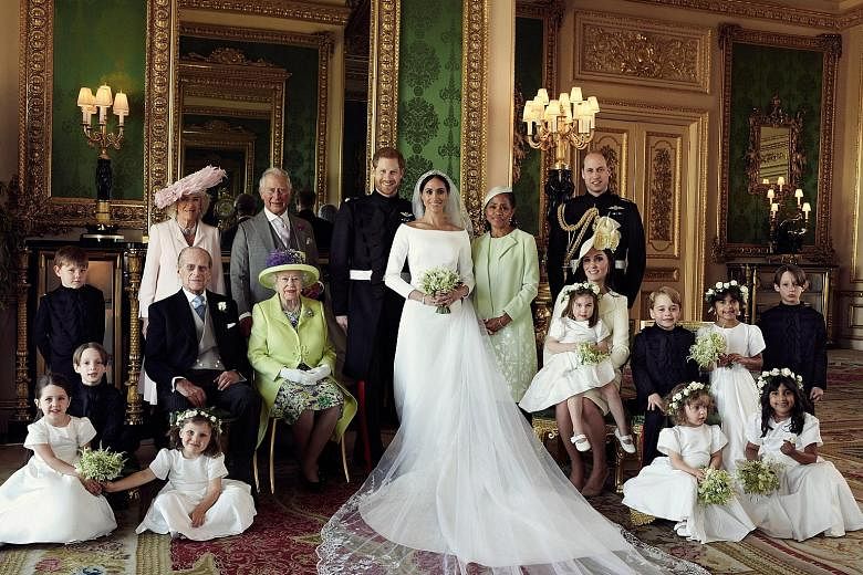 A photo released on Monday by Kensington Palace showing Britain's Prince Harry, the Duke of Sussex (centre), and his new wife Meghan, the Duchess of Sussex, in the Green Drawing Room of Windsor Castle, taken last Saturday. They were joined for the ph
