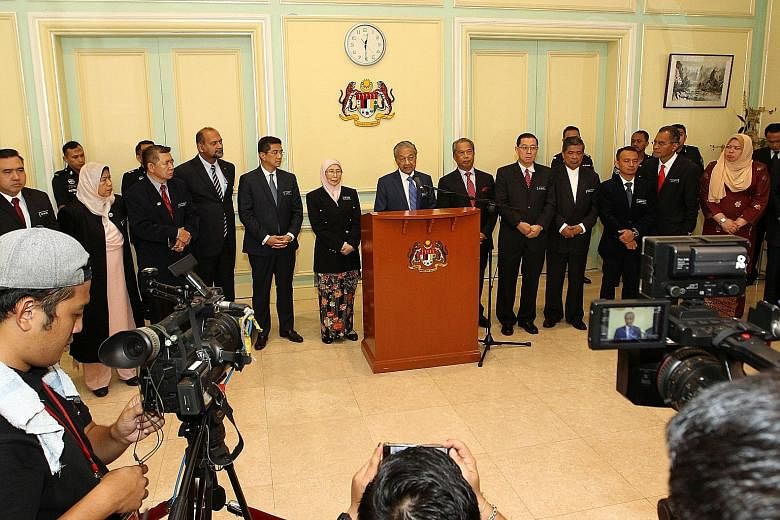 Malaysian Prime Minister Mahathir Mohamad, accompanied by his Cabinet members, giving a news conference after their meeting in Putrajaya yesterday. The government is grappling with a huge debt left behind by the previous administration.