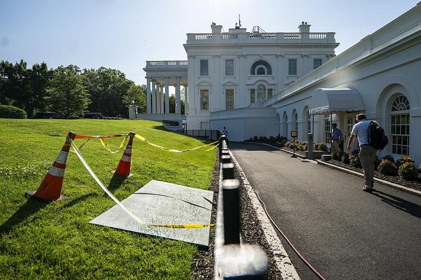 A wooden board yesterday covering a sinkhole in the North Lawn of the White House, just outside the press briefing room.