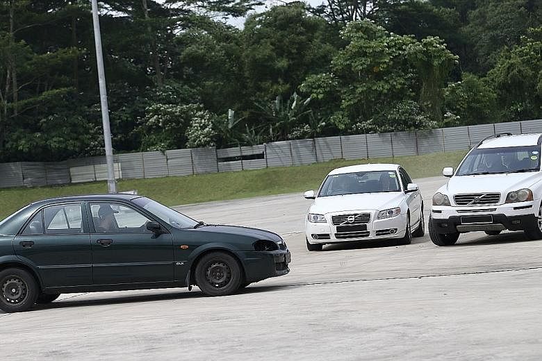 Left: ST journalist Charmaine Ng, assuming the role of a VIP in this simulation exercise, being whisked away to a getaway car by Police Security Command officers after the four-car VIP convoy was "attacked" by gunfire. Right: Police SecCom officers (