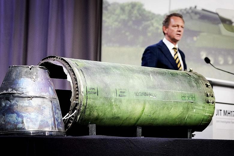 Dutch prosecutor Fred Westerbeke speaks next to a part of the Buk rocket fired at MH17 over Ukraine, during the press conference in Bunnik, Holland, yesterday.