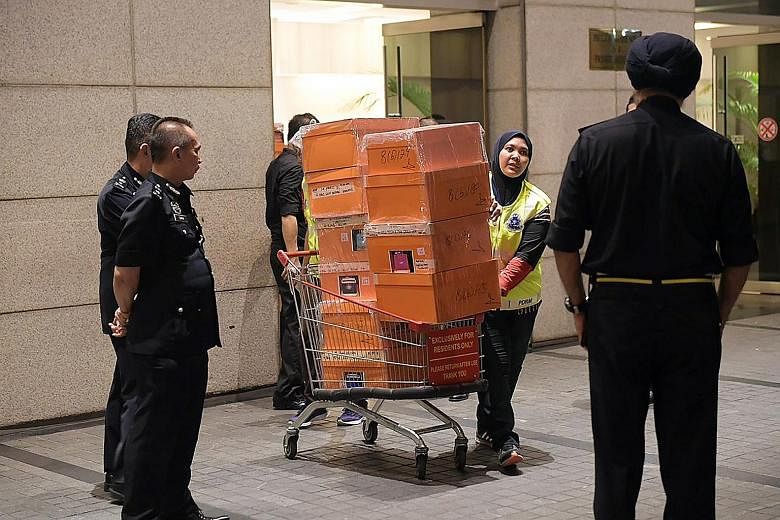 Malaysian police removing items in a raid last week from three apartments in an upmarket Kuala Lumpur condominium linked to former prime minister Najib Razak's family. The police carted away bags filled with jewellery, cash, watches and other valuabl