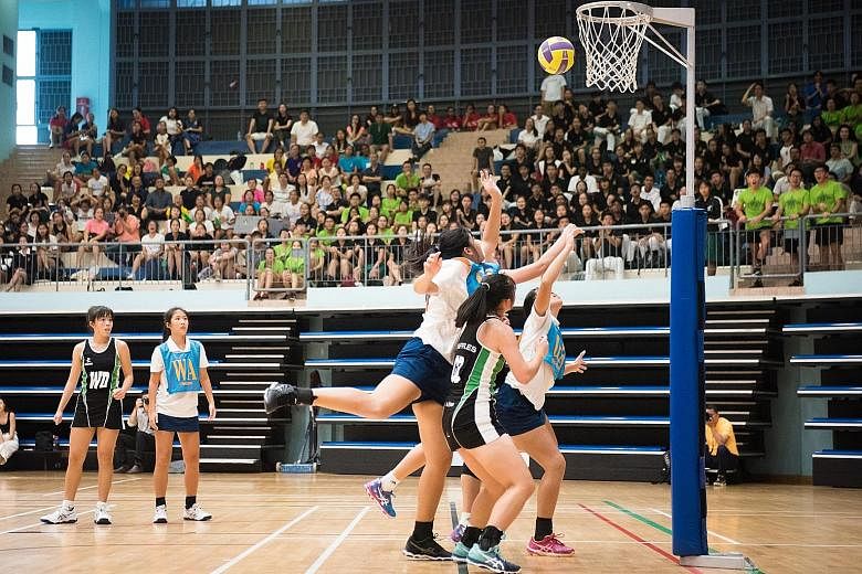 ACJC (in blue and white) on the attack against RI with goal shooter Syntyche Yeo (third from right) and goal attack Kaylee Lim. They won 38-34 for their first A Division netball title since 2013.