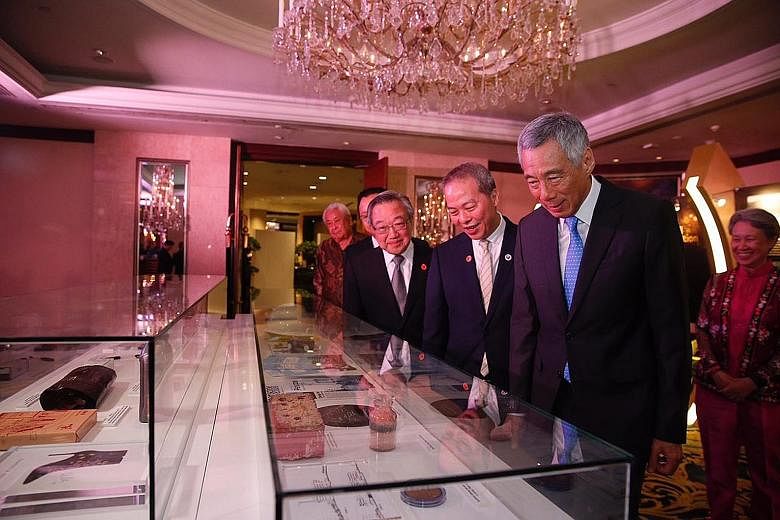 Prime Minister Lee Hsien Loong viewing the items of a time capsule that will be placed on June 1 in JTC's first permanent headquarters at Jurong Town Hall. With him are (from left) Datuk Seri Lim Chong Keat, architect of the original Jurong Town Hall