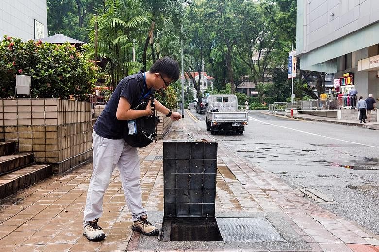 Above: Murky water flooding Cavenagh Road near Kramat Lane yesterday. Left: Heavy rain pelting down in the afternoon in Chinatown. Contractor Toh Wei Kian checking the drains in the Orchard Road area to see if any needed repair.