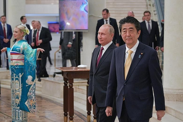 Russian President Vladimir Putin (left) and Japanese Prime Minister Shinzo Abe at the opening ceremony of the Year of Japan in Russia last Saturday. The leaders pledged to move forward on a peace treaty to solve a territorial dispute over the Kuril i