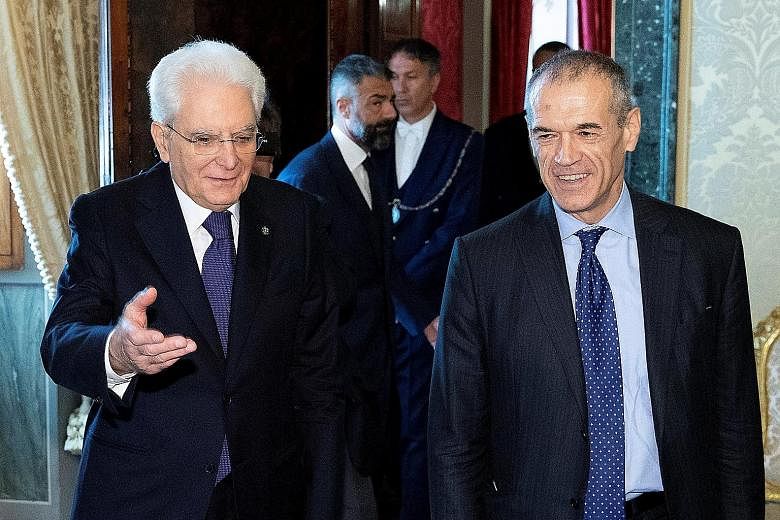 Italian President Sergio Mattarella (left) welcoming caretaker prime minister Carlo Cottarelli to Quirinal Palace in Rome for talks. Mr Cottarelli said elections could be held after August if his government loses a parliamentary vote of confidence, o