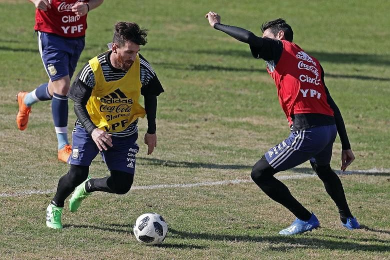 Argentina's Lionel Messi (left) tries to get past team-mate Angel di Maria during training in Buenos Aires on Sunday before their friendly match against Haiti today. Besides an Olympic gold in Beijing 2008, Messi has never won a major tournament with