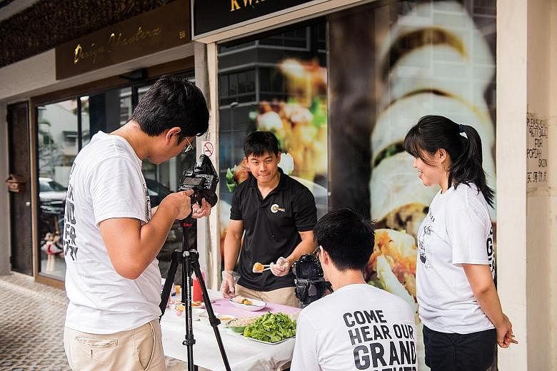 Our Grandfather Story team with (foreground, from left) Mr Ng Kai Yuan, Mr Matthew Chew and Ms Carine Tan, filming a clip. Their first video, which featured pink and green ice-cream bread from Jackson Bakery & Confectionery in Bedok, had over 150,000