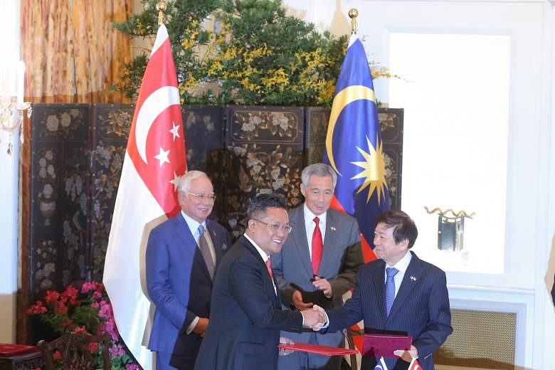 Malaysia's then Minister in the Prime Minister's Department Abdul Rahman Dahlan (left) and Singapore's Coordinating Minister for Infrastructure and Transport Minister Khaw Boon Wan at the Istana in January, after signing a pact to build a cross-borde