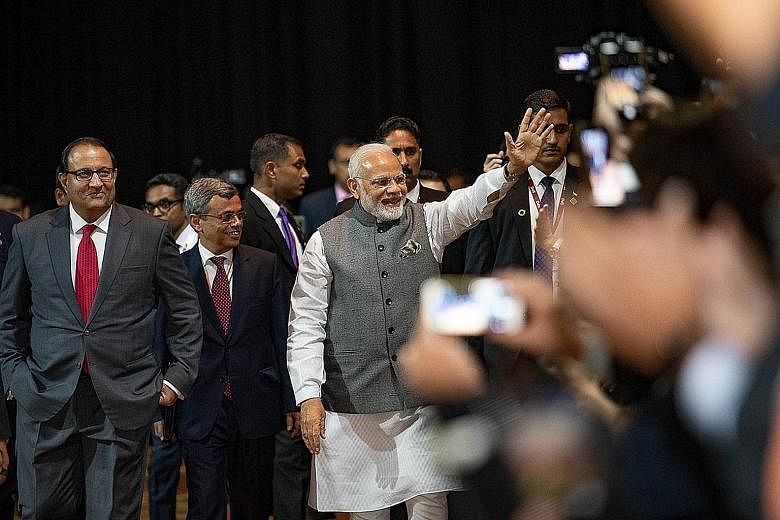 Visiting Indian Prime Minister Narendra Modi waving to businessmen at a Singapore-India business event at the Marina Bay Sands Convention Centre yesterday. With him are Minister-in-charge of Trade Relations S. Iswaran (far left) and India's High Comm