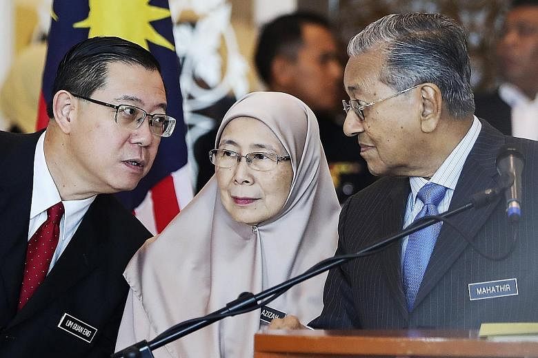 From left: Malaysian Finance Minister Lim Guan Eng, Deputy Prime Minister Wan Azizah Wan Ismail and Prime Minister Mahathir Mohamad at a press conference in Putrajaya on Wednesday.