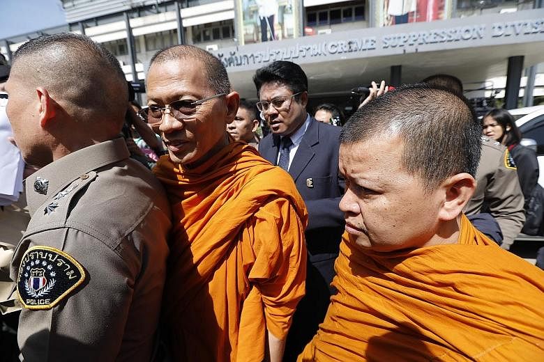 Buddhist monks Phra Promdilok (left) and Phra Attakitsophon leaving the Police Crime Suppression Division in Bangkok after questioning last week.