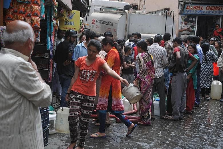 Shimla residents gathering to collect water in buckets from a water tanker yesterday. They are getting water once a week, compared with up to several times a day before the drought.