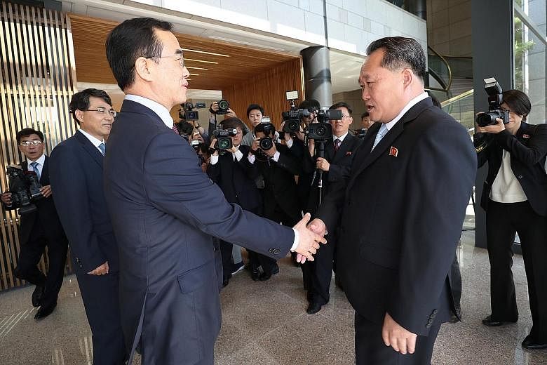 South Korean Unification Minister Cho Myoung Gyon (at left) shaking hands with North Korea's chief delegate Ri Son Gwon at the Peace House on South Korea's side of the truce village of Panmunjom. They each led a team of five to the high-level talks y