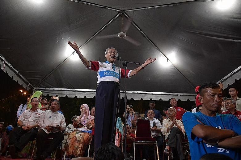 Tun Dr Mahathir Mohamad speaking at an election rally in Melaka on May 4. Also present at the rally were Pakatan Harapan leaders and former Cabinet ministers, including Tun Daim Zainuddin (right).