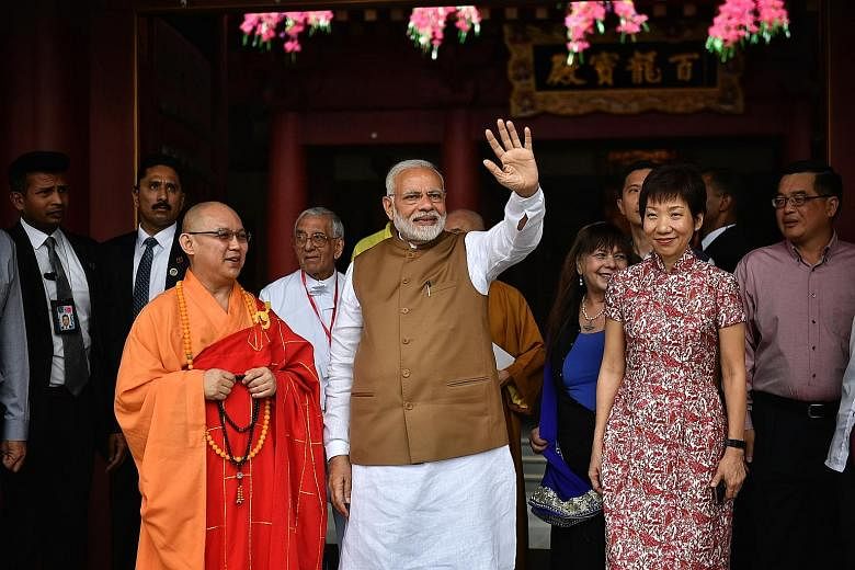Indian Prime Minister Narendra Modi with Minister for Culture, Community and Youth Grace Fu at the Buddha Tooth Relic Temple and Museum (right) in South Bridge Road yesterday. He also unveiled a plaque (far right, above) at Clifford Pier, marking the