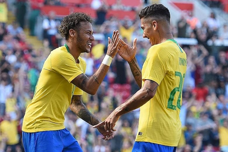 Substitute Neymar celebrating with Roberto Firmino after the latter scored Brazil's second goal at Anfield yesterday. Brazil beat Croatia 2-0 in their World Cup warm-up match.