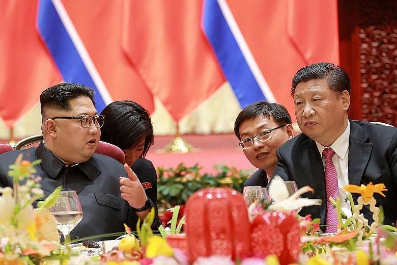 Mr Kim Jong Un with Chinese President Xi Jinping at a banquet in the city of Dalian during the North Korean leader's visit to China on May 7. The writer says China has always been, and always will be, a pushing hand behind the resolution of the Korea