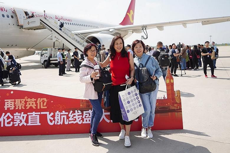 Passengers posing for photos before boarding a direct flight from Xi'an's airport to London on May 7. The new service by Tianjin Airlines cuts the journey from 15-plus hours to around 11 hours.