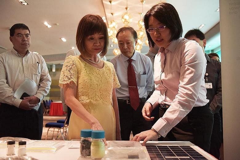 Singapore Polytechnic research scientist Thong Ya Xuan (right) showing Dr Amy Khor, Senior Minister of State for the Environment and Water Resources, a new development that can help the recycling and waste management industry at the poly yesterday.