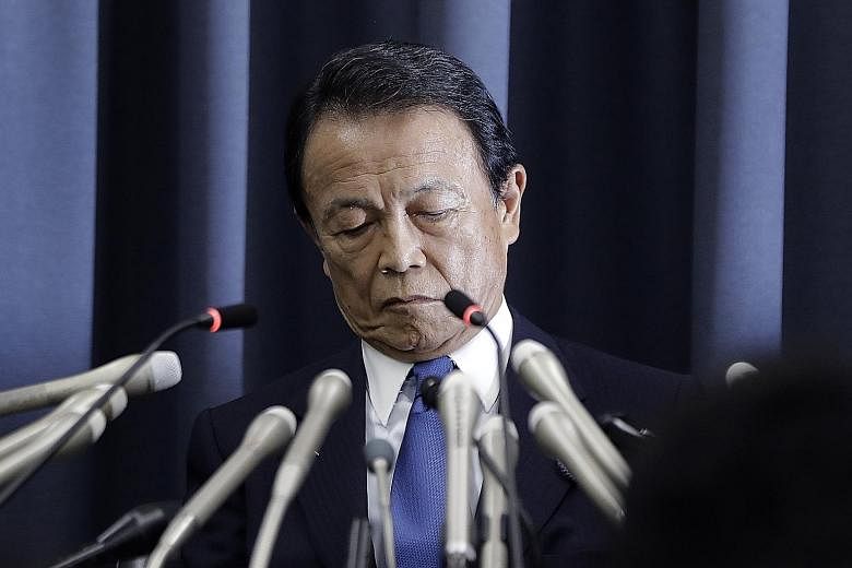 Japanese Finance Minister Taro Aso at a news conference in Tokyo yesterday. He said that in the light of an internal ministry probe, some 20 ministry officials will be punished with either a fine, suspension, pay cut or warning.