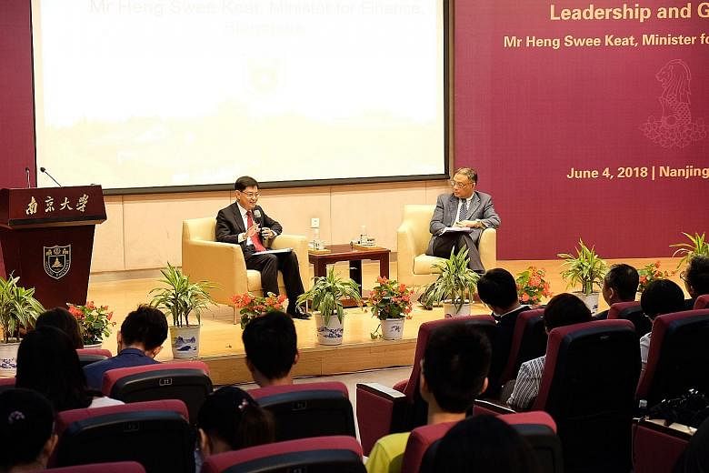 Finance Minister Heng Swee Keat engaging with Nanjing University students yesterday as dialogue moderator, Professor Zhu Feng of the university's Institute of International Studies, looks on. Mr Heng is on a nine-day working visit to China with stops