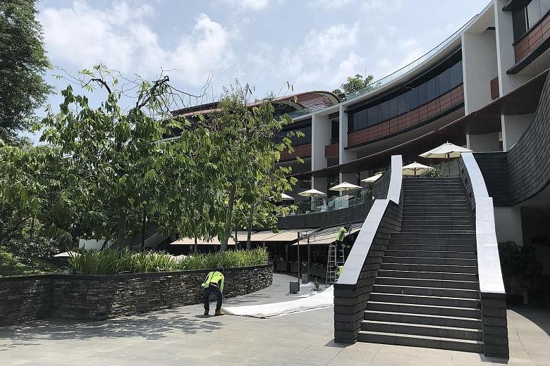 Set among 12ha of lush vegetation, Above: Workers sprucing up Capella Singapore's facade and grounds yesterday. The luxury hotel is owned by the Kwee family of Pontiac Land Group. Below: A curtained-off area guarded by security cameras on the second 