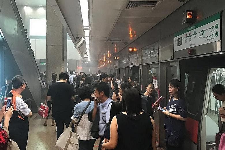 Commuters on the smoky platform at Tanjong Pagar MRT station yesterday morning. The train with the leaking air-conditioning compressor was withdrawn from service for checks, said SMRT.