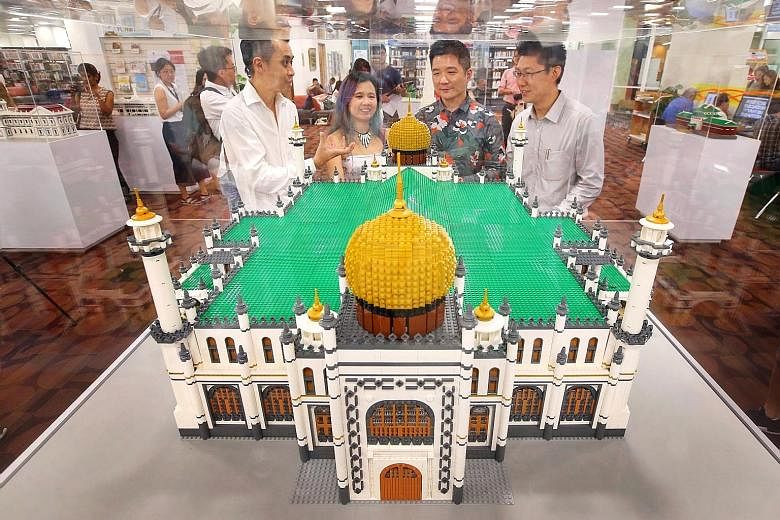 Left: Brick artists Eugene Tan and Xylvie Wong, with the National Heritage Board's Mr Alvin Tan and Mr Ian Lee, at the Lego model of Sultan Mosque during the opening of the Building History: Monuments In Bricks And Blocks travelling exhibition at the