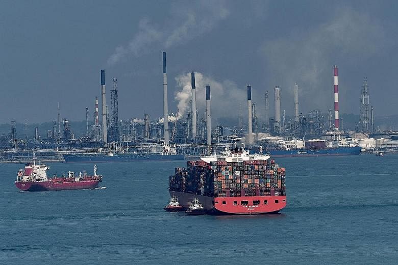 A container vessel in waters off Pulau Bukom. The report said Singapore's economy is forecast to expand by 3 per cent this year, slowing from last year's 3.6 per cent. Export-led manufacturing is tipped to moderate although it will be partly offset b