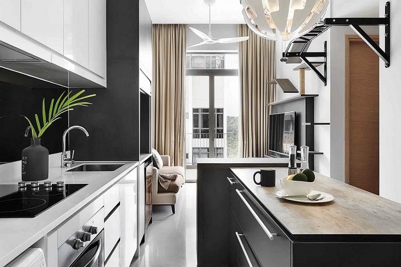 The space below the dining table conceals the food bowls and cat litter of the owner's pets, hence keeping the area visually clutter-free. A modern contemporary vibe permeates the apartment (left). The space below the loft (above) is an ideal spot fo