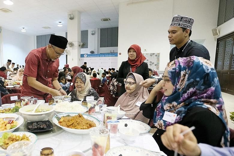 Minister-in-charge of Muslim Affairs Masagos Zulkifli serving food at Pertapis Senior Citizen Fellowship Home during the Ramadan Disbursement Ceremony yesterday. He said the move to revise eligibility criteria for zakat assistance comes amid inflatio