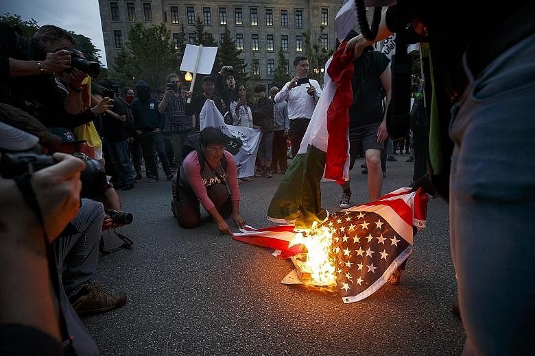 Protesters burning flags of G-7 member countries at a demonstration on Thursday outside the National Assembly of Quebec. Finance ministers from the other six countries in the G-7 have condemned US President Donald Trump's trade decisions in an extrao