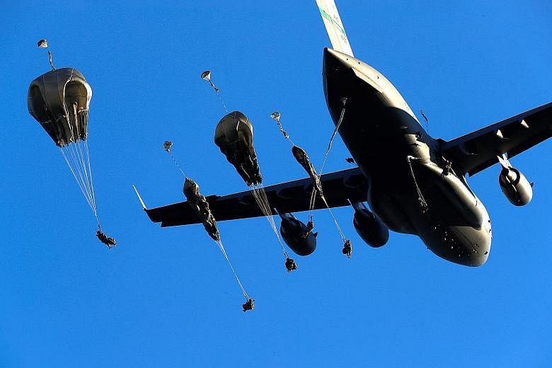 United States Army paratroopers dropping out of a C-17 aircraft during the Nato exercise Swift Response 2018 in Adazi, Latvia, yesterday. Swift Response is a series of exercises taking place in Eastern Europe that is designed to strengthen the abilit