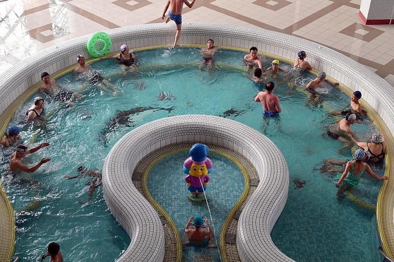 Farmers and workers head back to their ancestral homes on a weekend outside Jang Chon Cooperative farm, which is a 30-minute drive from Pyongyang. Above: The state-run Munsu Water Park covers 15ha and has nine pools, nine saunas and water rides - all