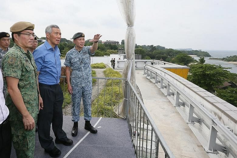 Prime Minister Lee Hsien Loong speaking to officers on duty during his visit to the Home Team command post in Novena yesterday. PM Lee with Chief of Defence Force Melvyn Ong (left) and Director of Joint Operations Tan Chee Wee on the rooftop of Sento