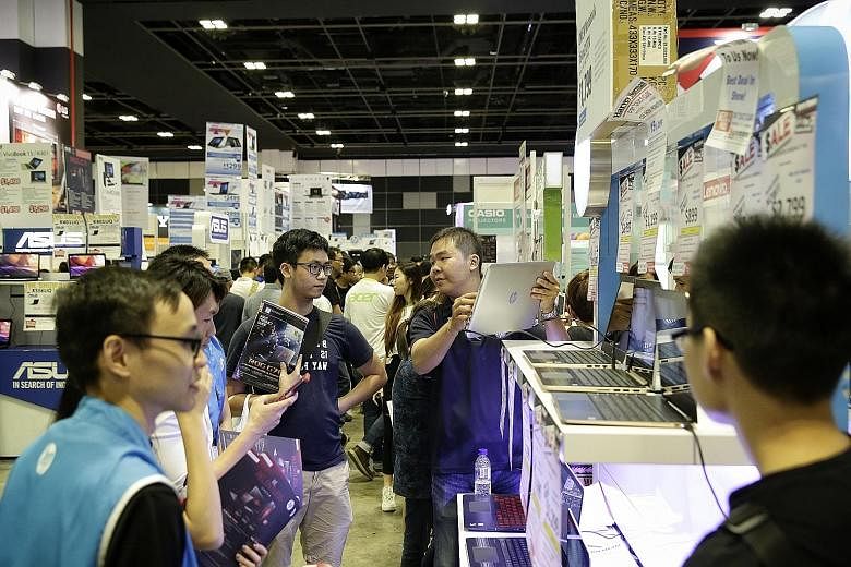 Visitors at the Consumer Electronics Exhibition in Suntec Singapore last year. The sharp fall in demand for computer and telecommunications equipment was the main cause of lacklustre retail sales in April this year.
